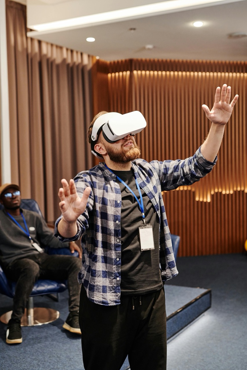Mężczyzna testuje gogle VR w nowoczesnym wnętrzu – przykład zastosowania wirtualnej rzeczywistości w innowacyjnych technologiach, edukacji i biznesie